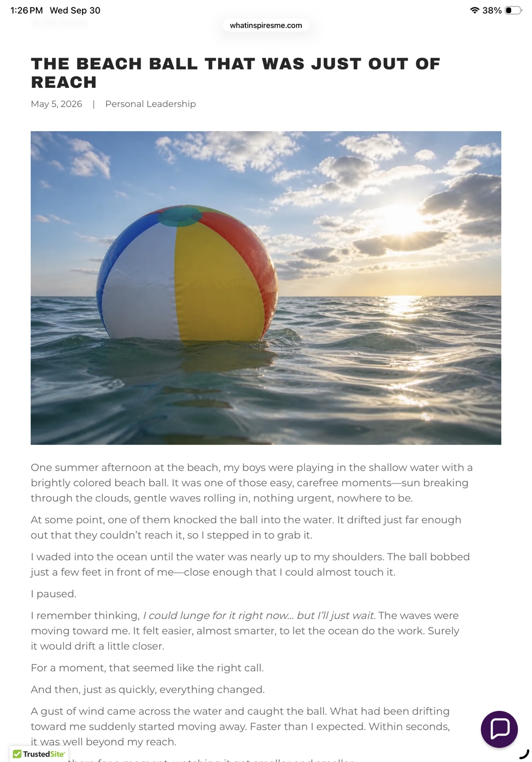 A colorful beach ball floating on the ocean at sunset.